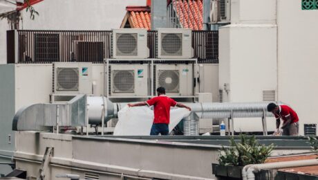 AC technicians servicing rooftop unit Air conditioning technicians servicing an outdoor unit on a rooftop